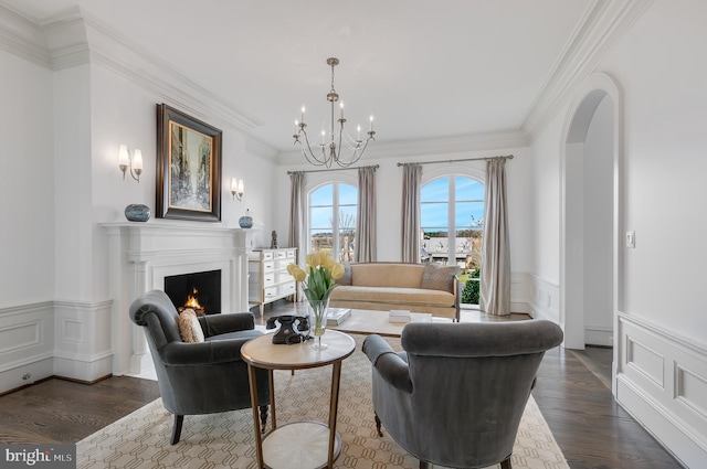 living room featuring dark hardwood / wood-style flooring, crown molding, and an inviting chandelier