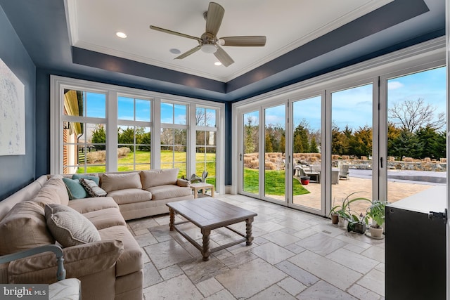 sunroom / solarium with a raised ceiling and ceiling fan