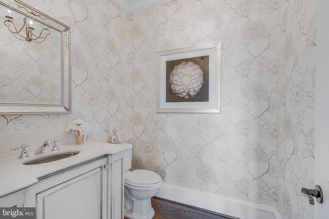 bathroom featuring crown molding, vanity, wood-type flooring, and toilet