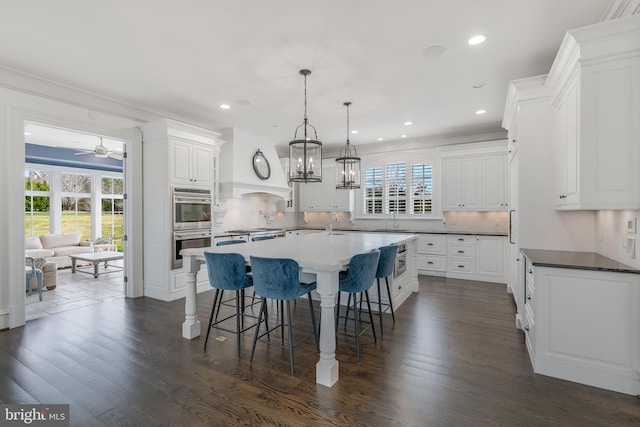 kitchen with ceiling fan, white cabinetry, dark wood-type flooring, and a wealth of natural light