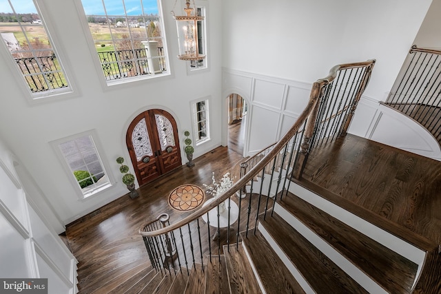 foyer entrance with plenty of natural light, a towering ceiling, and french doors