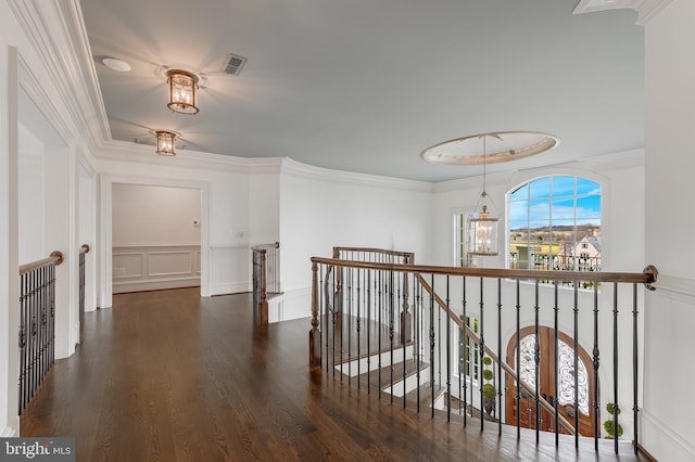 hallway featuring ornamental molding, dark wood-type flooring, and a notable chandelier