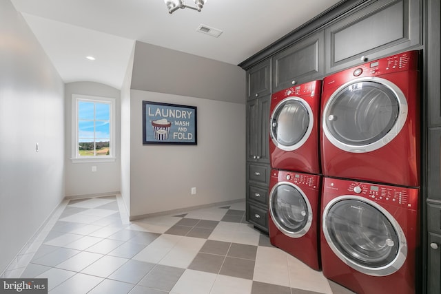 laundry room with washer and dryer, cabinets, light tile patterned floors, and stacked washer and clothes dryer