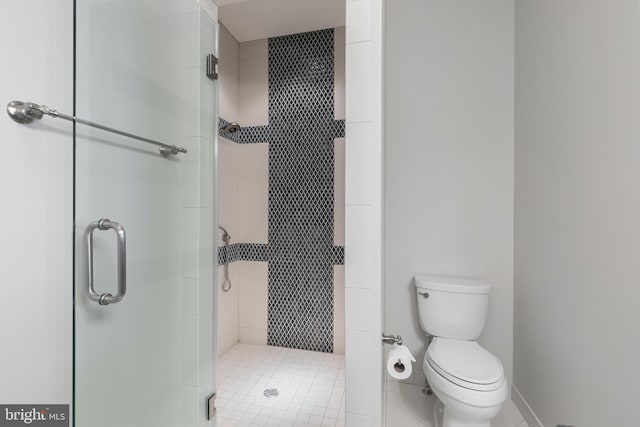 bathroom featuring tile patterned floors, toilet, and a shower with door