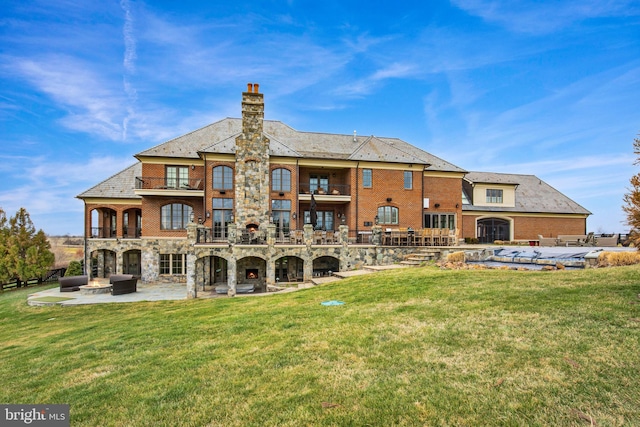 back of house with a lawn, a balcony, and a patio