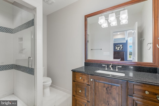 bathroom featuring tile patterned floors, vanity, toilet, and a shower with door