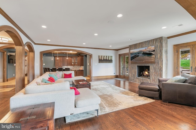 living room with a fireplace, hardwood / wood-style floors, and ornamental molding