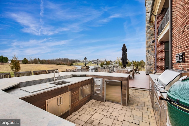 view of patio / terrace with exterior kitchen, sink, and grilling area