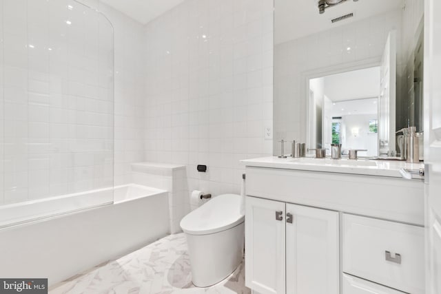 full bathroom with tile walls, toilet, tiled shower / bath combo, tile floors, and large vanity