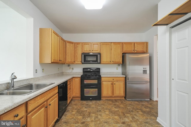 kitchen featuring sink, dark tile flooring, and black appliances