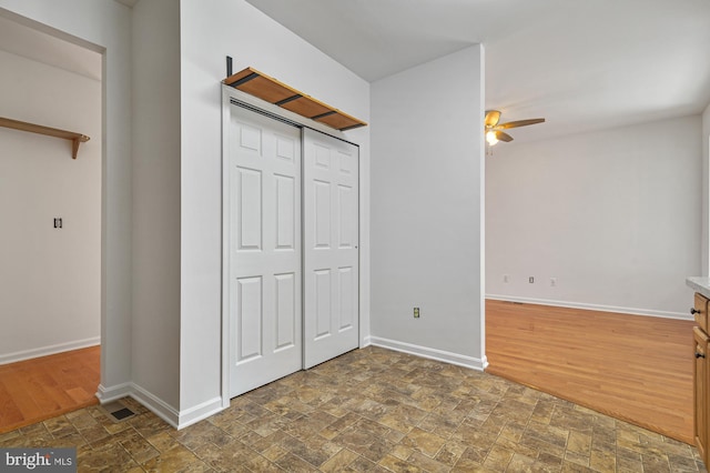 unfurnished bedroom with dark tile floors and ceiling fan