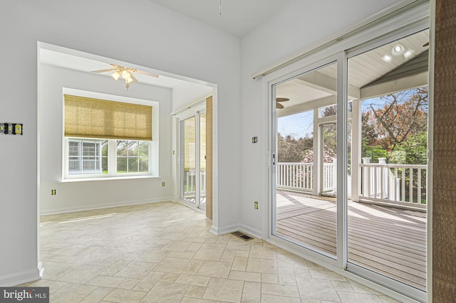 doorway featuring light tile floors and ceiling fan