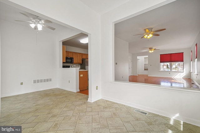 unfurnished living room with ceiling fan and light tile floors