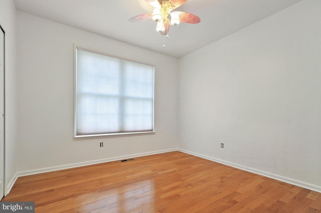 empty room with a wealth of natural light, ceiling fan, and light hardwood / wood-style flooring