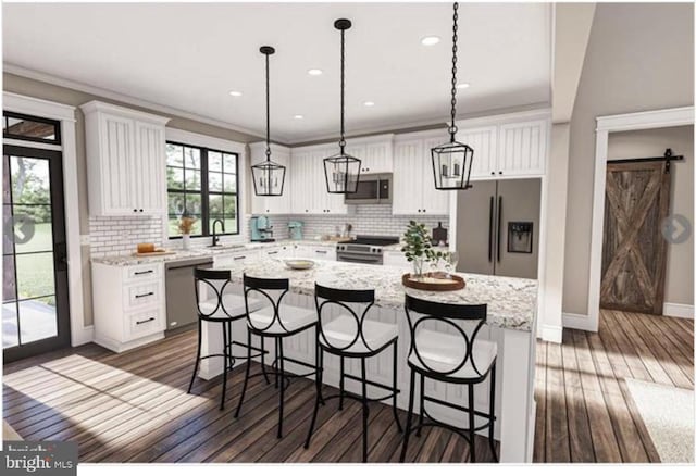 kitchen with a center island, a barn door, white cabinetry, and stainless steel appliances