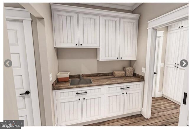 kitchen with white cabinets, sink, and hardwood / wood-style floors