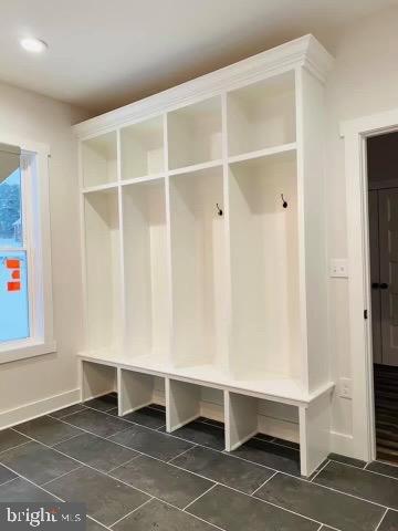 mudroom with dark tile patterned floors