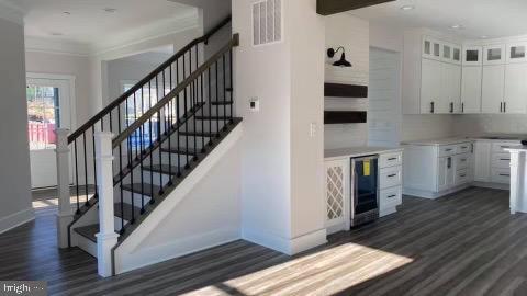 kitchen featuring decorative backsplash, dark hardwood / wood-style flooring, white cabinetry, and beverage cooler