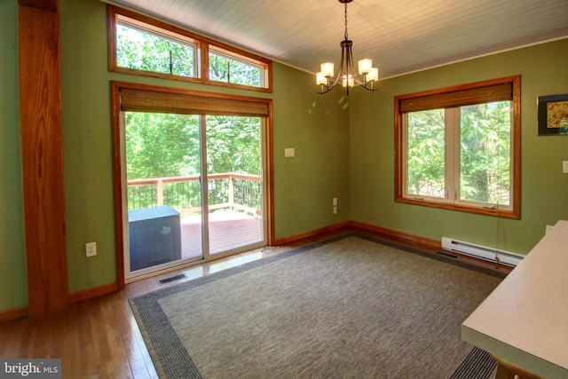 unfurnished dining area featuring a wealth of natural light, a baseboard radiator, and hardwood / wood-style flooring