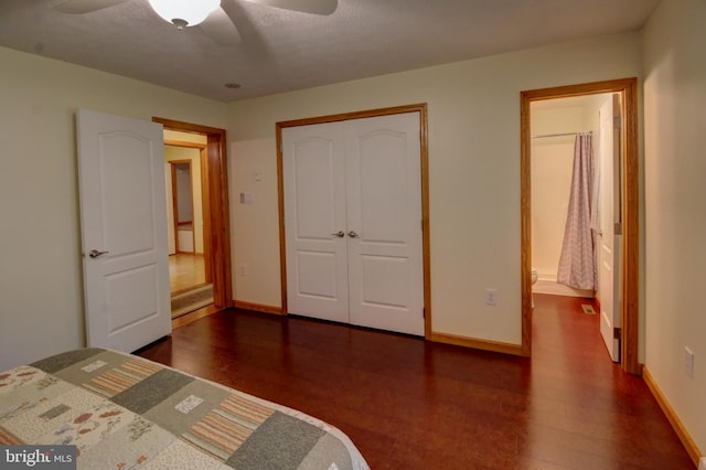 unfurnished bedroom with a closet, a textured ceiling, dark hardwood / wood-style floors, ceiling fan, and ensuite bathroom