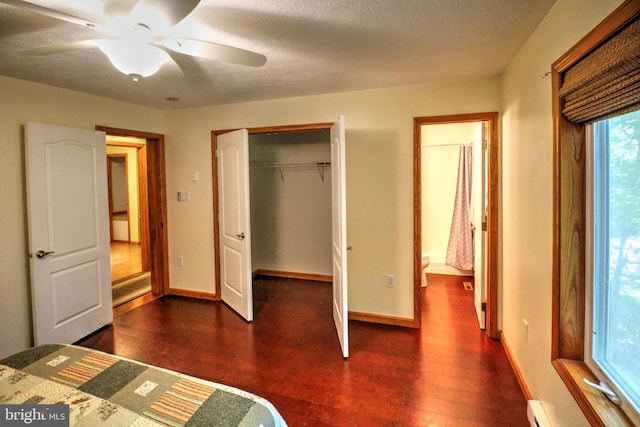 unfurnished bedroom with a closet, a textured ceiling, dark hardwood / wood-style flooring, a baseboard radiator, and ceiling fan