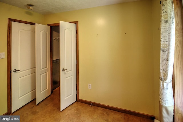 unfurnished bedroom with a textured ceiling and light carpet