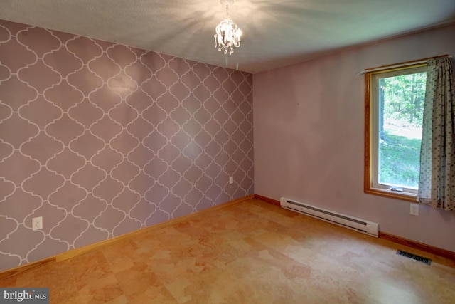 spare room with a textured ceiling, baseboard heating, and a notable chandelier