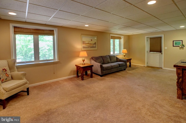 living room with light colored carpet, a paneled ceiling, and a healthy amount of sunlight