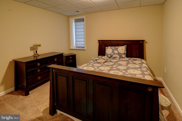 bedroom with a paneled ceiling and light colored carpet