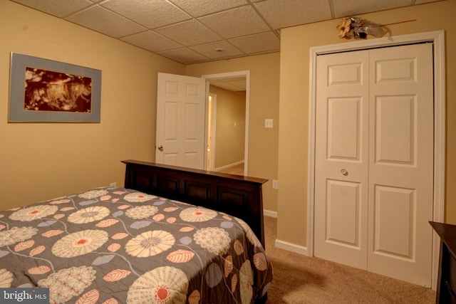 bedroom featuring a closet, a paneled ceiling, and carpet floors