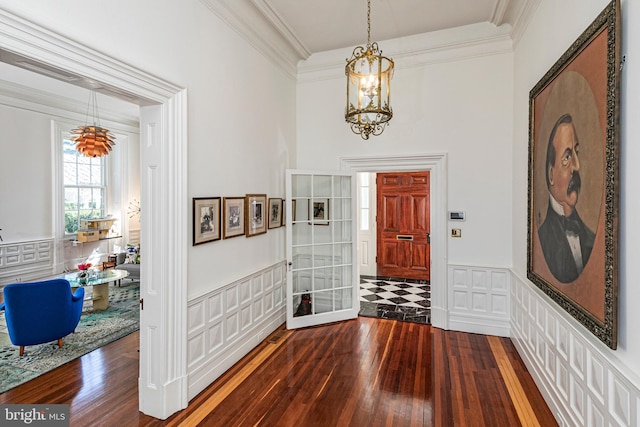 foyer featuring dark hardwood / wood-style floors, a notable chandelier, and crown molding