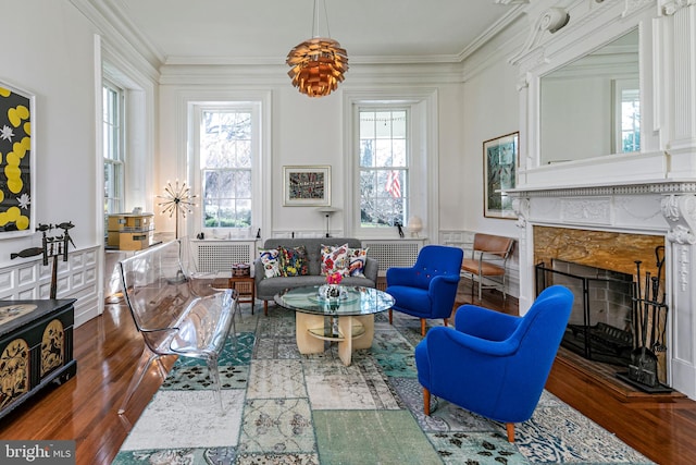 living room featuring crown molding, a fireplace, and dark wood-type flooring