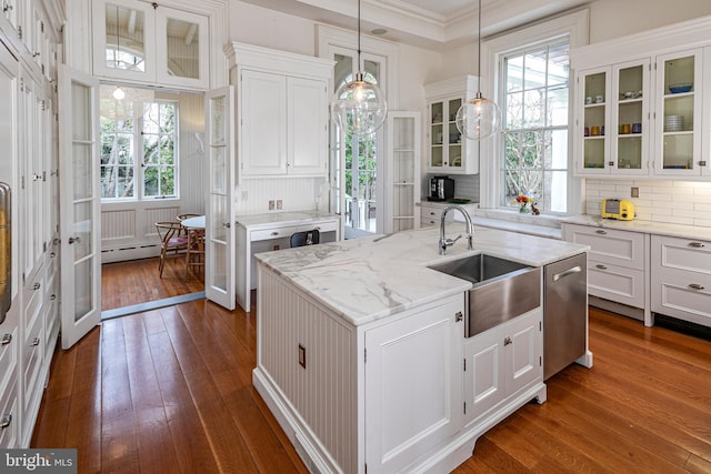 kitchen featuring a kitchen island with sink, hanging light fixtures, white cabinetry, dark hardwood / wood-style floors, and sink