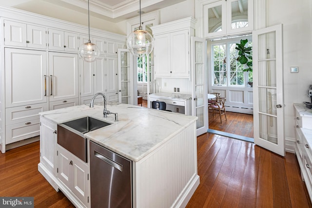 kitchen with dark hardwood / wood-style flooring, a kitchen island with sink, white cabinetry, pendant lighting, and stainless steel dishwasher