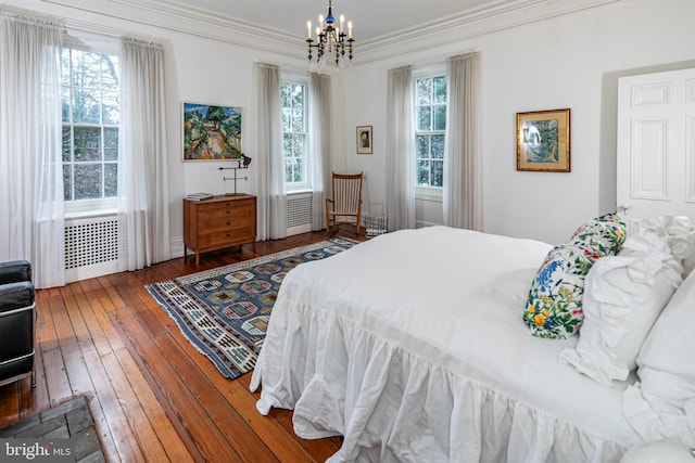 bedroom with crown molding, an inviting chandelier, dark hardwood / wood-style floors, and multiple windows