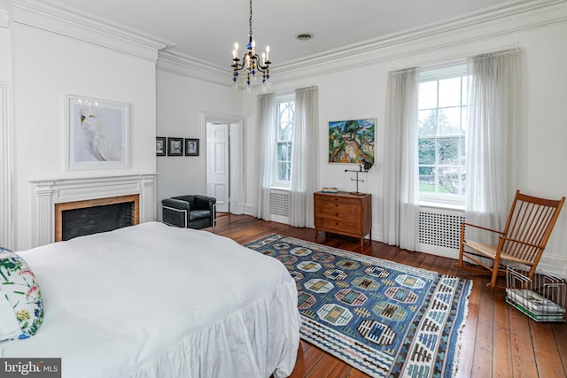 bedroom with dark hardwood / wood-style floors, an inviting chandelier, and ornamental molding