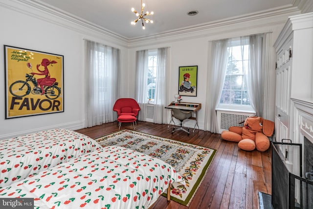 bedroom with ornamental molding, a notable chandelier, a fireplace, and dark hardwood / wood-style floors