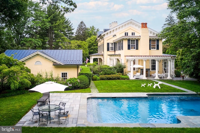 back of house featuring a yard and a patio area