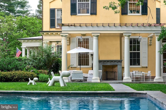 back of property featuring an outdoor hangout area, a yard, and a patio