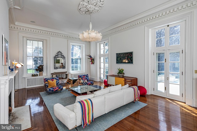 living room featuring french doors, dark wood-type flooring, an inviting chandelier, and ornamental molding