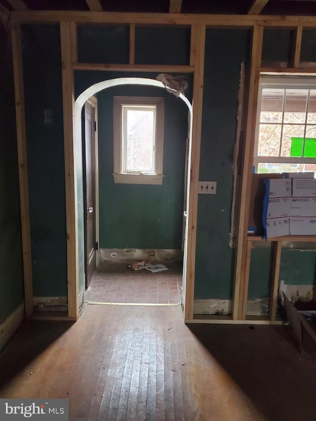 interior space featuring arched walkways and wood finished floors