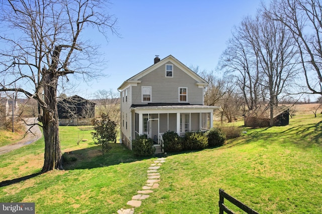 rear view of property featuring a lawn