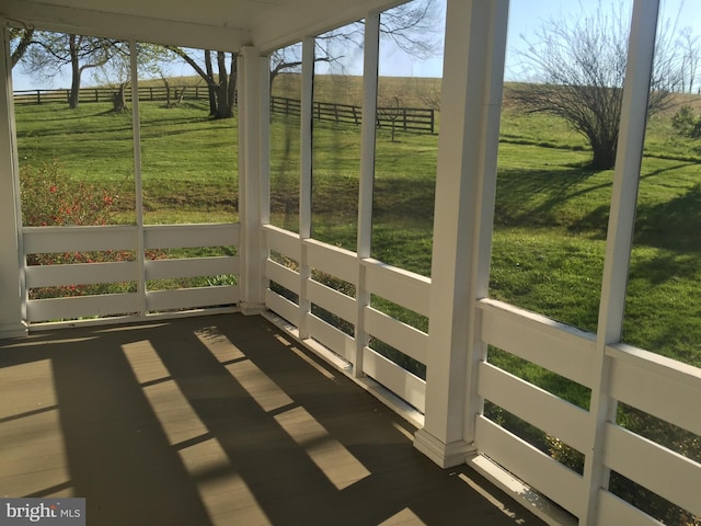 unfurnished sunroom featuring a rural view