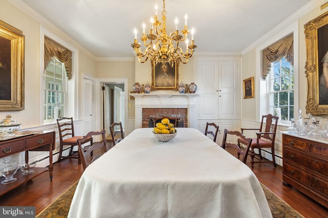 bedroom with crown molding, dark wood-type flooring, a notable chandelier, and a brick fireplace