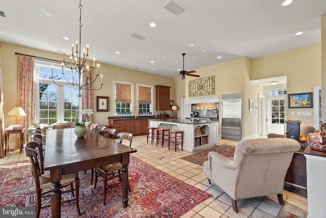 dining space with ceiling fan with notable chandelier