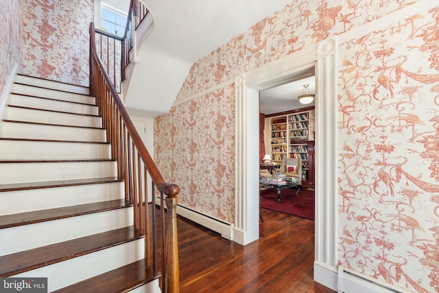 stairs featuring wood-type flooring and a baseboard radiator