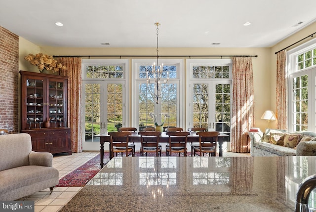 dining room featuring french doors, light tile patterned floors, and a notable chandelier