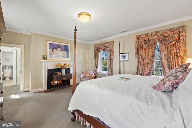 carpeted bedroom featuring connected bathroom and ornamental molding