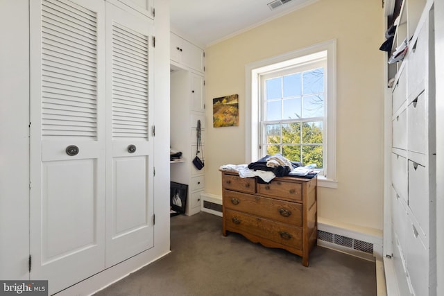 interior space with a closet, ornamental molding, and dark colored carpet