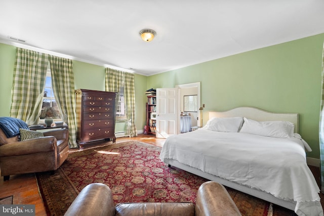 bedroom with multiple windows and hardwood / wood-style flooring